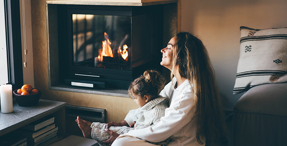 Mom and daughter in front of modern wood burning stove